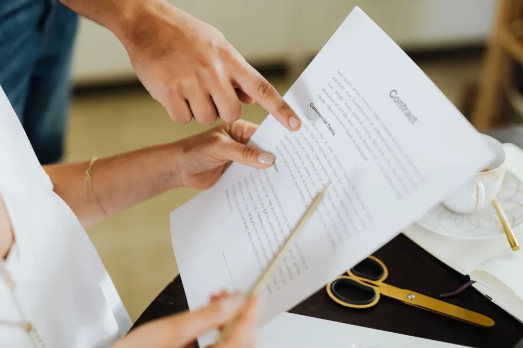 Pessoas revisando contrato após finalização de negociação