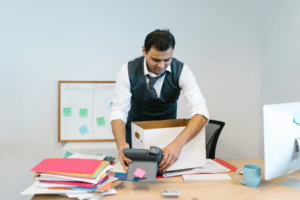 Homem organizando documentos em um escritório moderno.