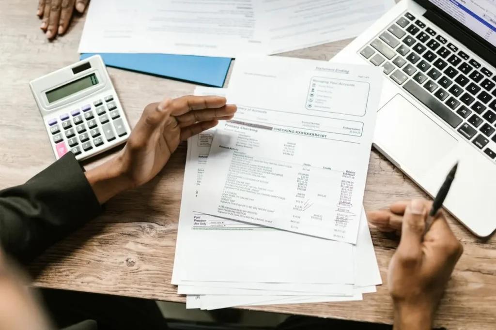 Pessoa revisando documentos financeiros na mesa